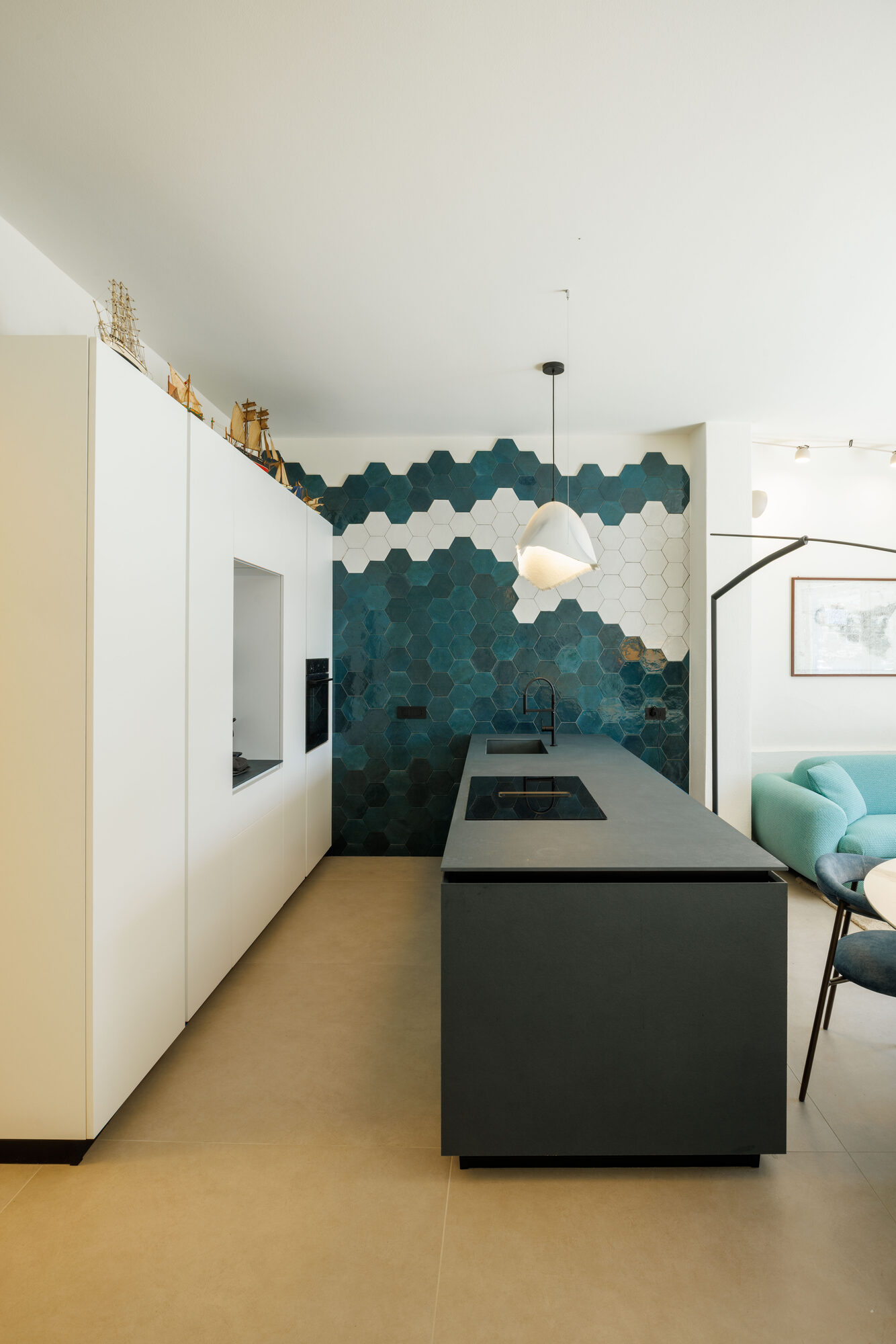 Cucina con isola scura e piastrelle esagonali blu